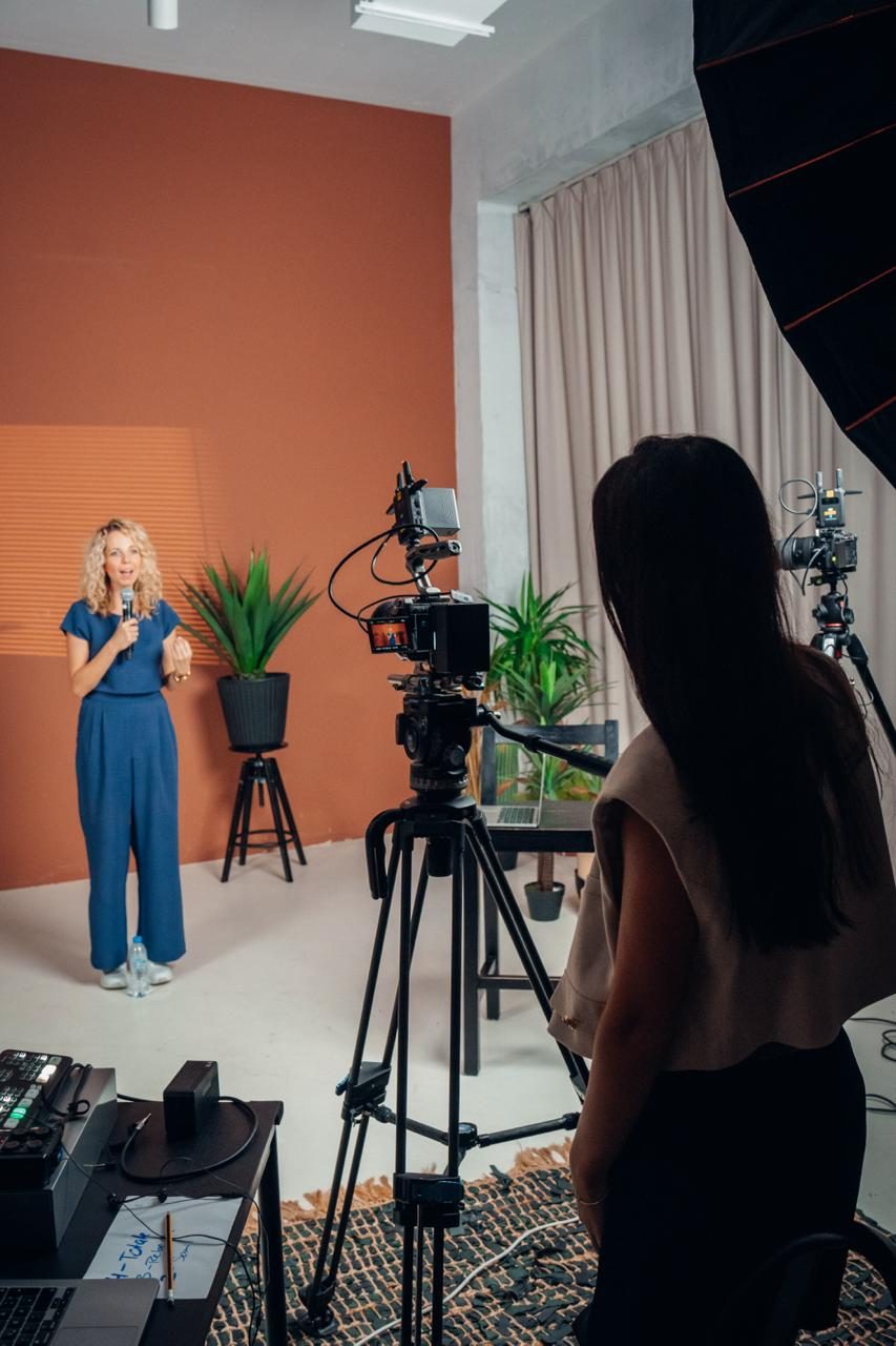 Kundin spricht beim Video-Shooting im Studio in die Kamera, Nancy begleitet sie